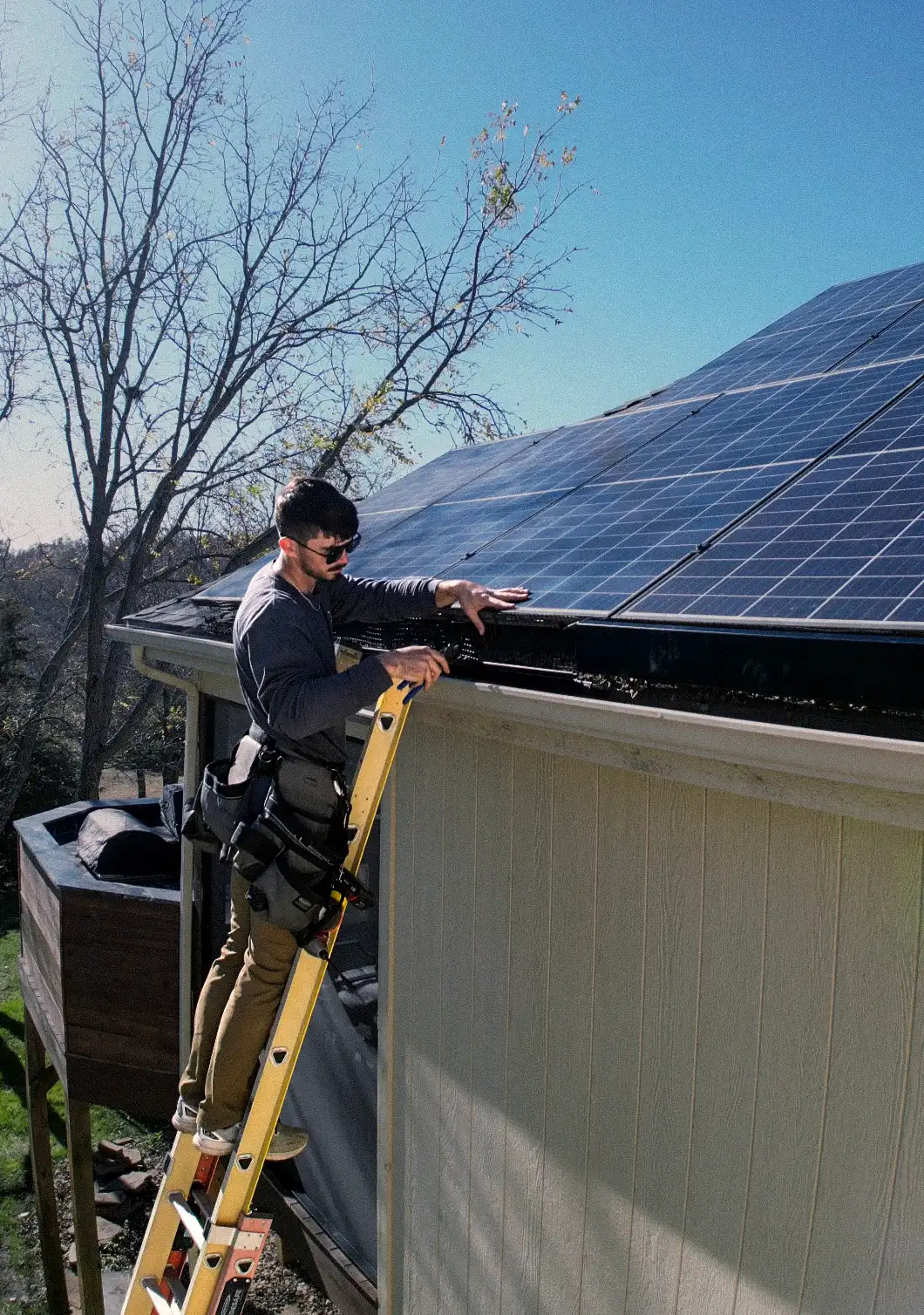 Solar Scapes technician installing animal guard beneath rooftop solar panels