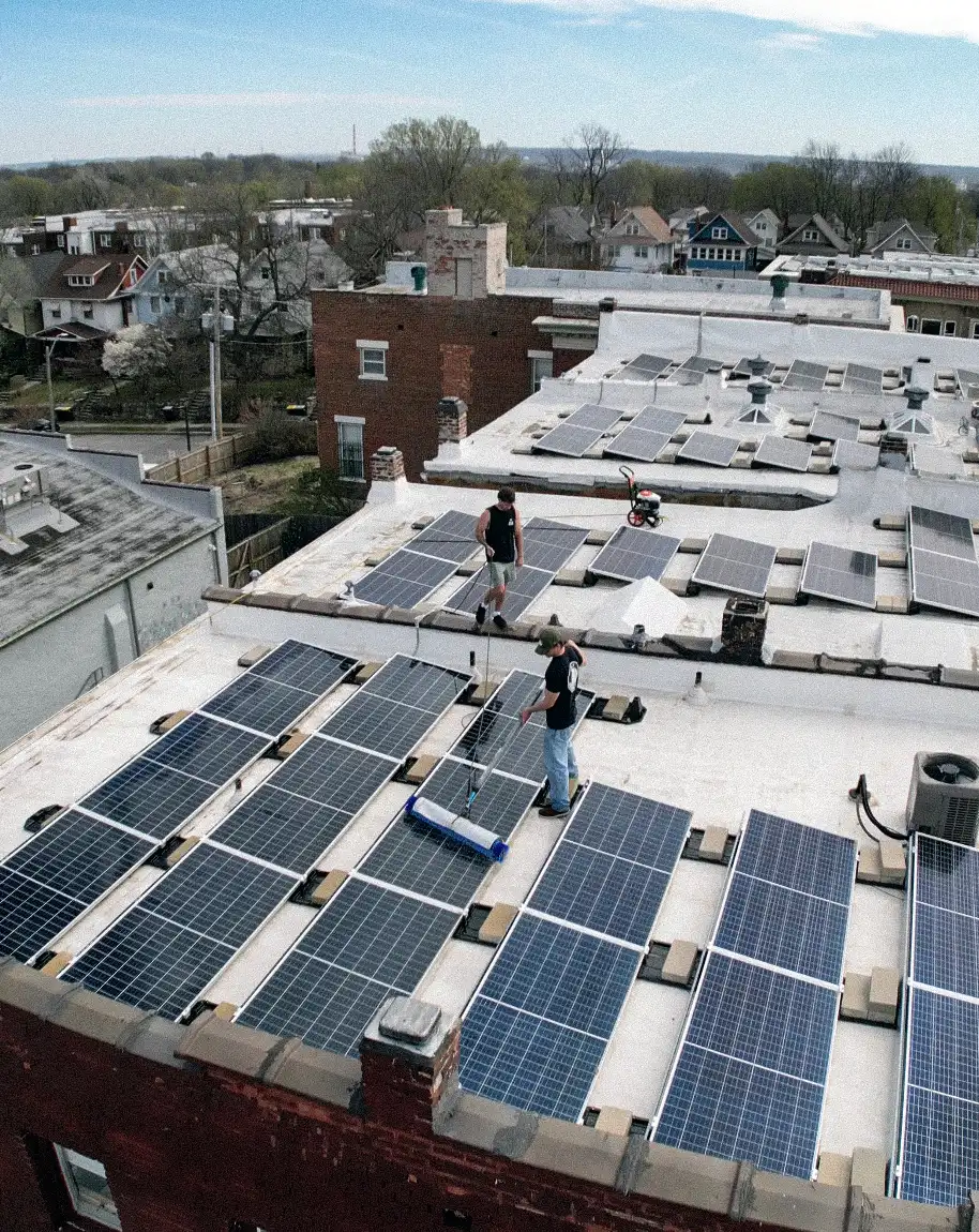 Solar Scapes technicians cleaning solar panels on a commercial rooftop